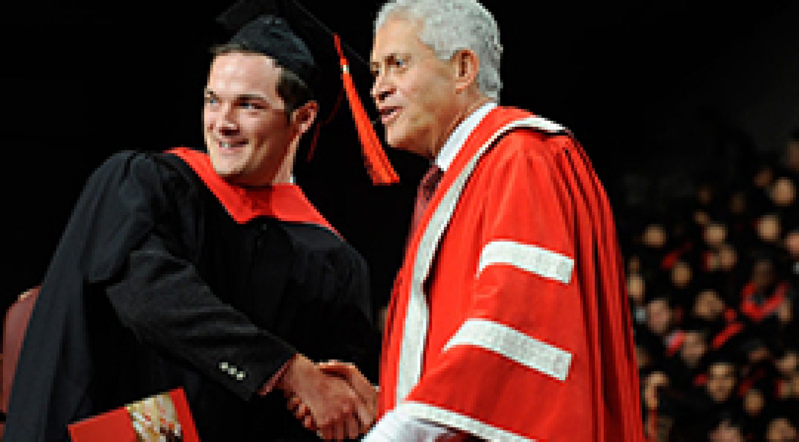 York U's President Mamdouh Shoukri shaking hands with a student during convocation