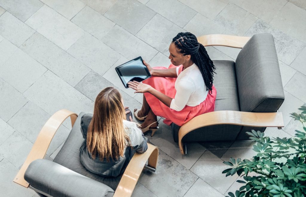 Overhead view of two business women having a meeting in an Office Lobby