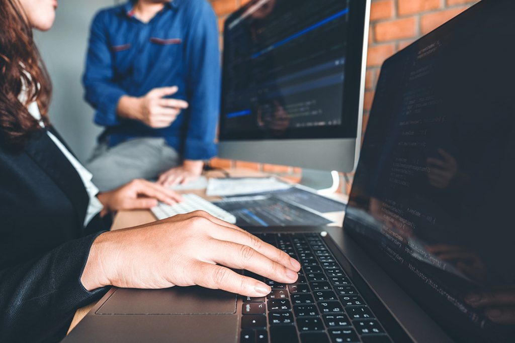 Cybersecurity practitioners working on a laptop.