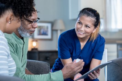 Home healthcare nurse with senior man and his adult daughter